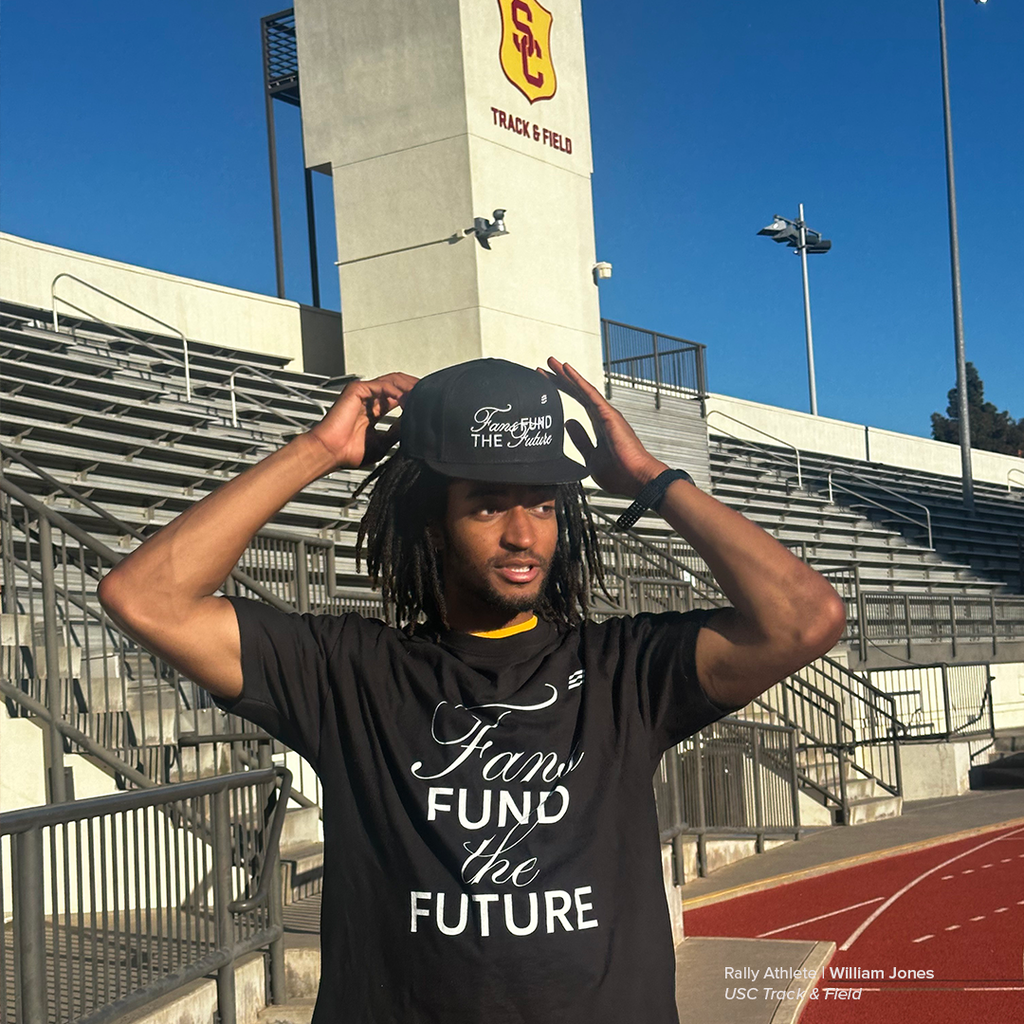 Person wearing a black t-shirt with text at a track and field stadium