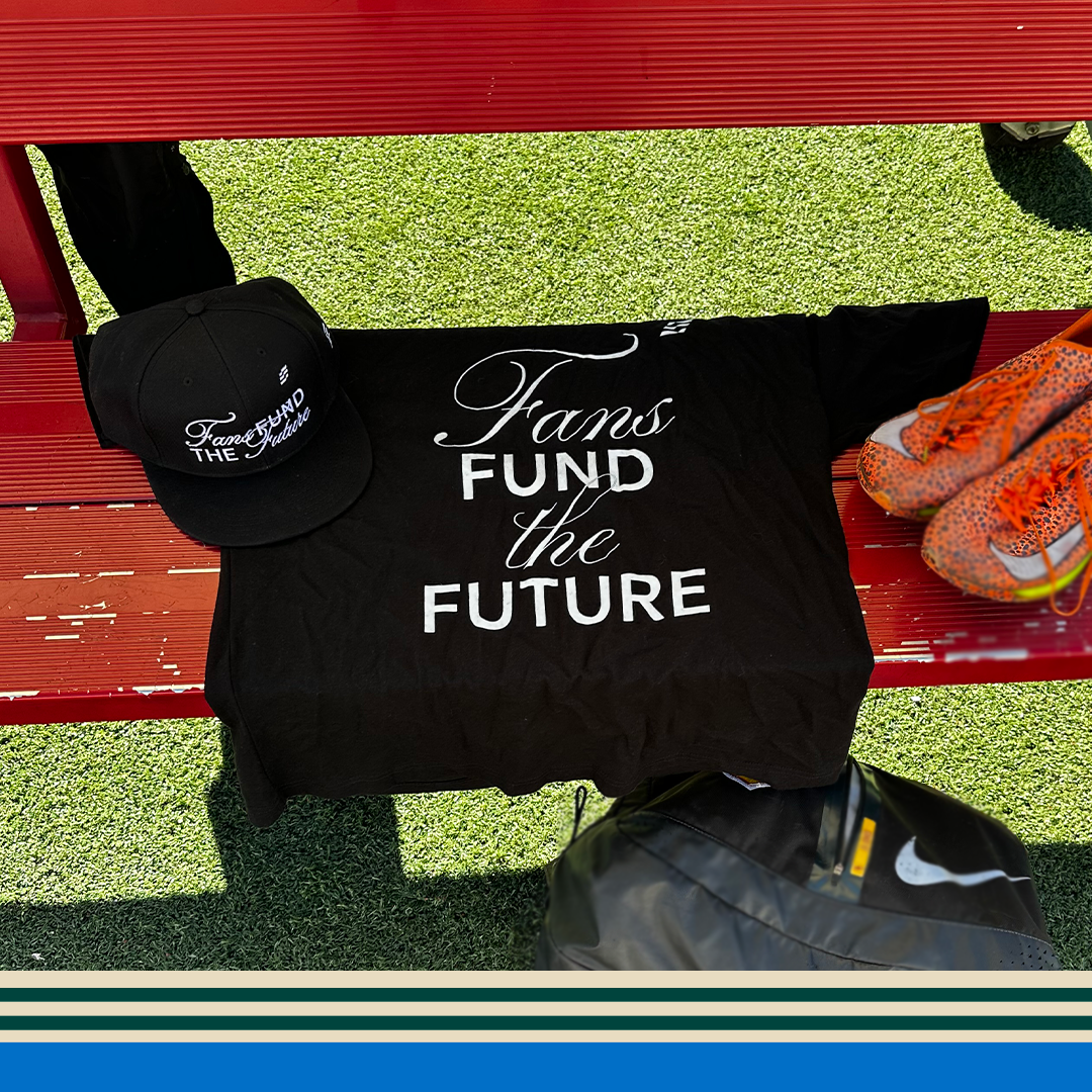 Black t-shirt with 'Fans Fund the Future' text, black cap, and orange cleats on a red bench.